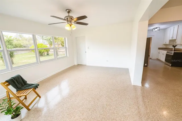 a view of a livingroom with a ceiling fan and window