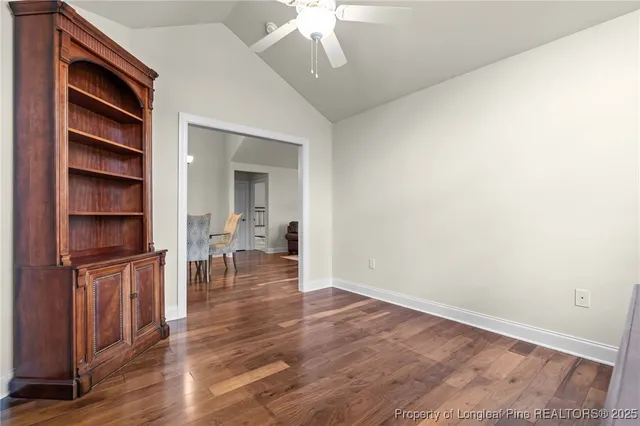 an empty room with wooden floor closet and windows