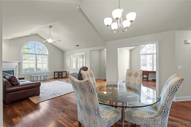 a view of a dining room with furniture a chandelier and a window