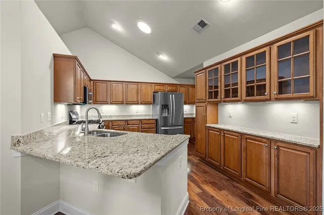 a kitchen with kitchen island granite countertop a sink and wooden cabinets