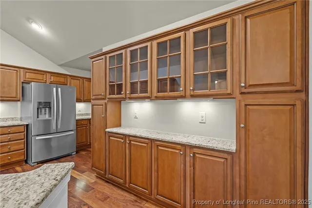 a kitchen with stainless steel appliances granite countertop a refrigerator and a sink
