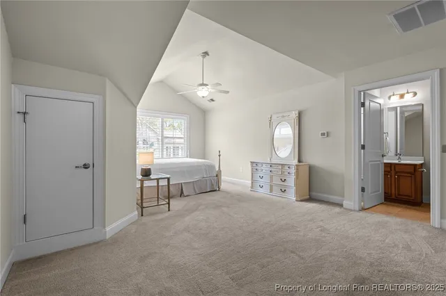 a spacious bedroom with a bed and a chandelier
