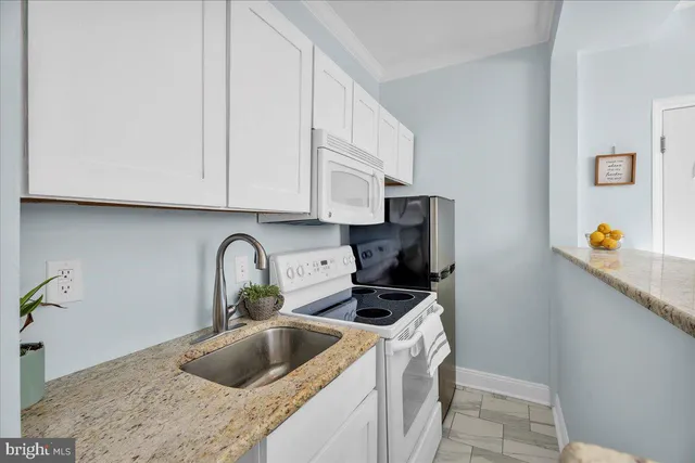 a kitchen with stainless steel appliances granite countertop a sink and a white cabinets