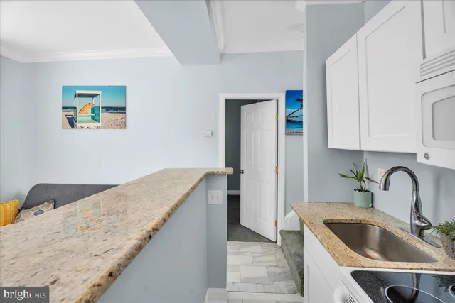 a kitchen with granite countertop a sink and a stove top oven