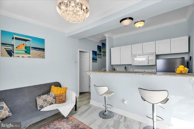 a kitchen with a table chairs and a living room