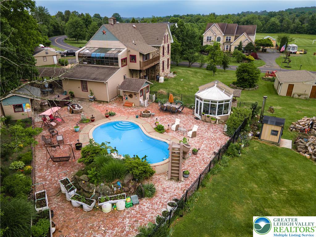 2485 Hieter Road Quakertown, PA 18951 - Photo 74 of 97 An inviting backyard oasis features a freeform pool surrounded by a brick patio, complete with a charming gazebo and lush greenery.