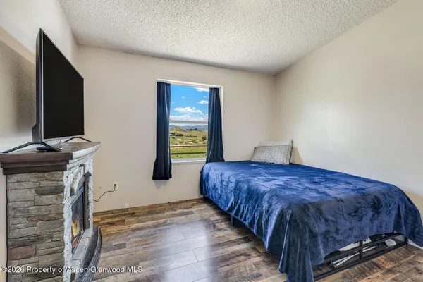 a bedroom with a bed and a flat tv screen on a dresser