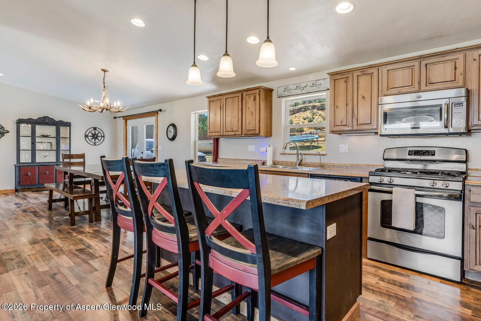 2880 County Road 233 Rifle, CO 81650 - Photo 6 of 47 a kitchen with stainless steel appliances kitchen island granite countertop a stove a sink a dining table and chairs with wooden floor