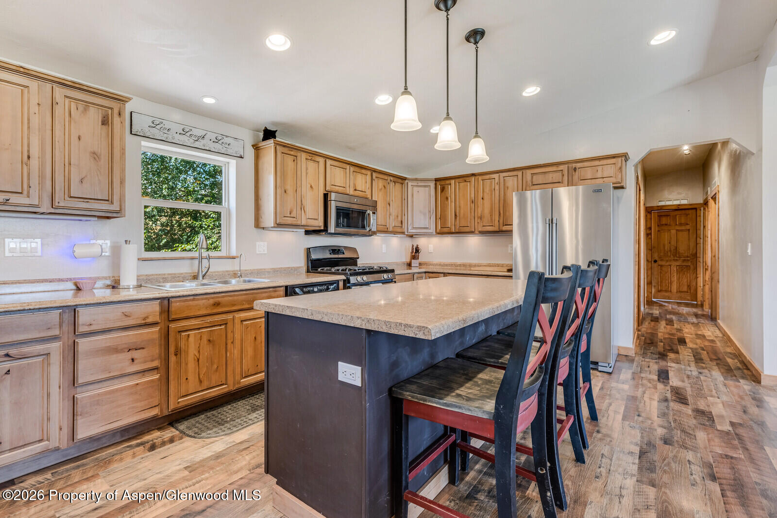 2880 County Road 233 Rifle, CO 81650 - Photo 7 of 47 a kitchen with stainless steel appliances granite countertop a table chairs sink refrigerator and cabinets