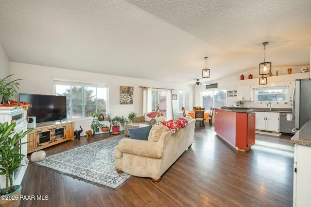 a living room with kitchen island furniture and a flat screen tv