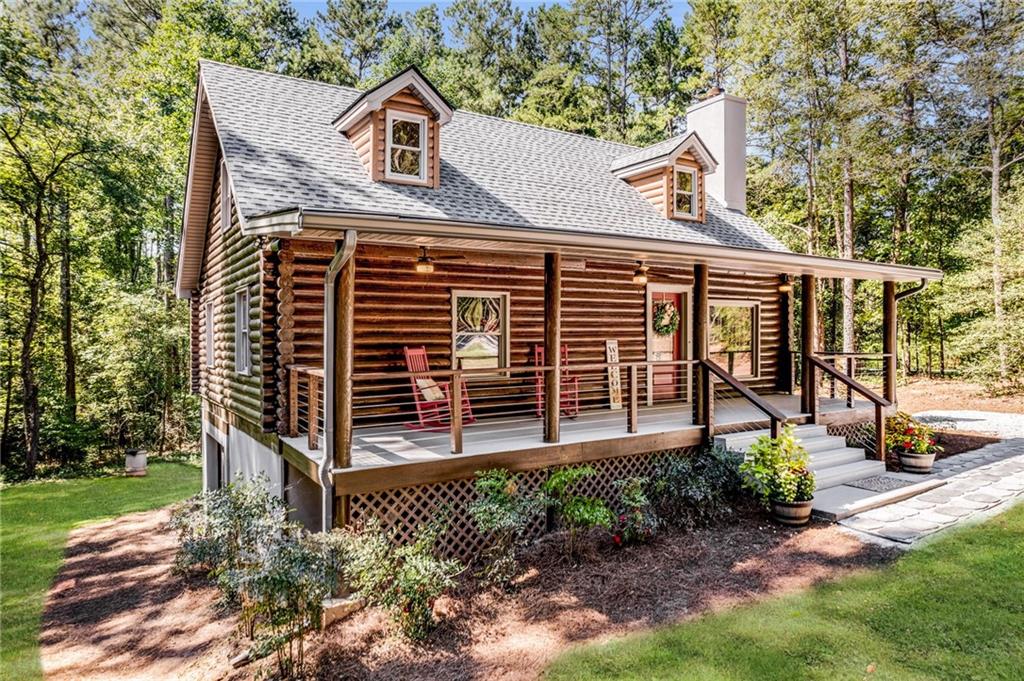 a view of a house with a yard and large tree