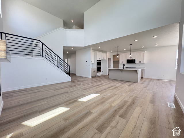 2633 Scarlet Road, Unit 259 Eagle Mountain, UT 84005 - Photo 5 of 29 Vaulted ceilings with recessed lighting, wood-finish flooring, and a contemporary staircase with black metal railings