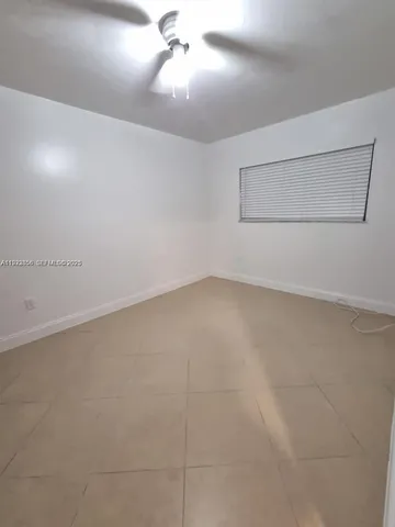 en empty room with windows and fan