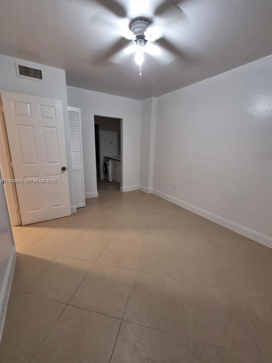 665 Northeast 83rd Terrace, Unit 112 Miami, FL 33138 - Photo 5 of 8 en empty room with windows and fan