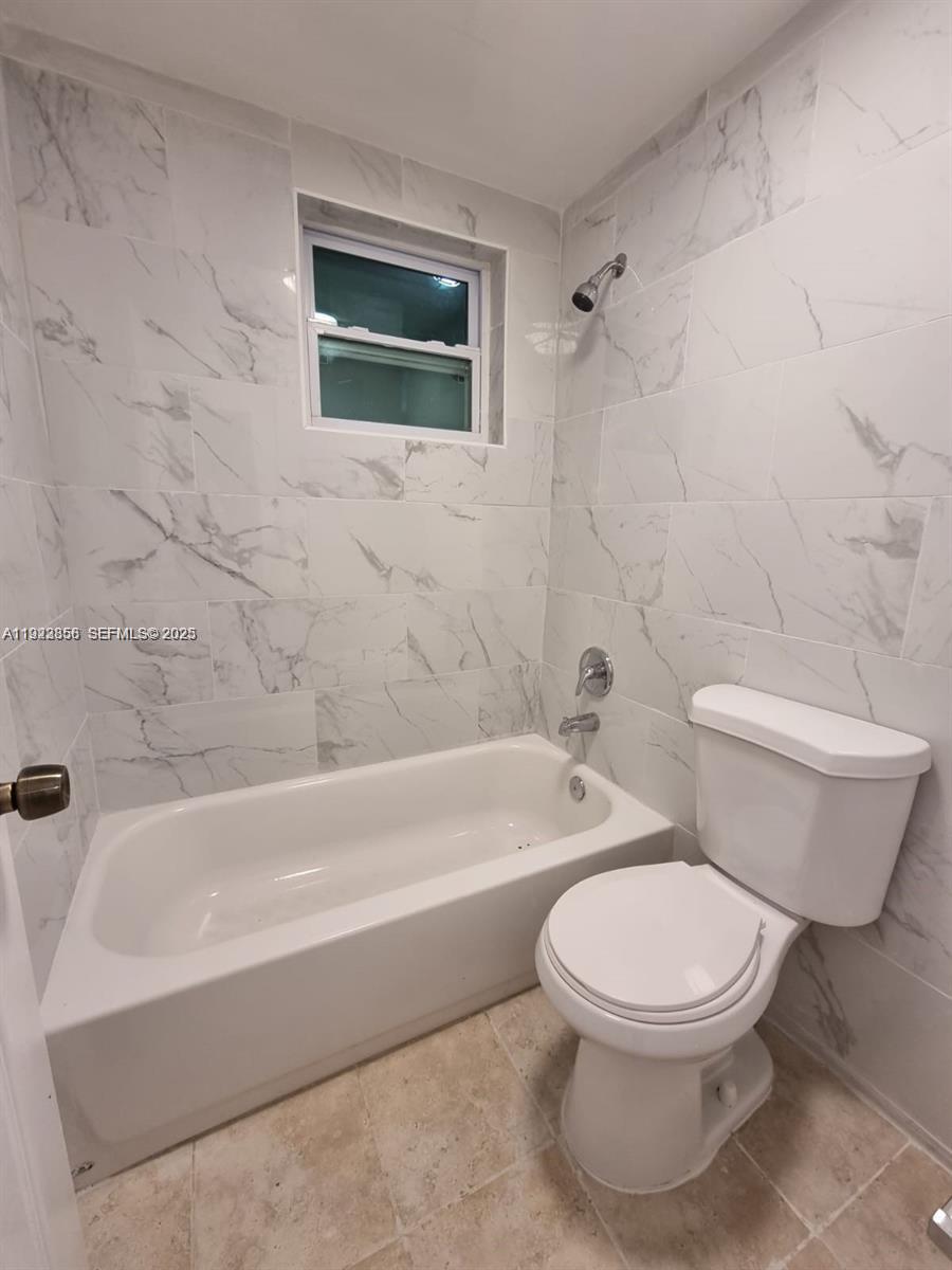 665 Northeast 83rd Terrace, Unit 112 Miami, FL 33138 - Photo 7 of 8 a white toilet and tub sitting next to a bathroom sink