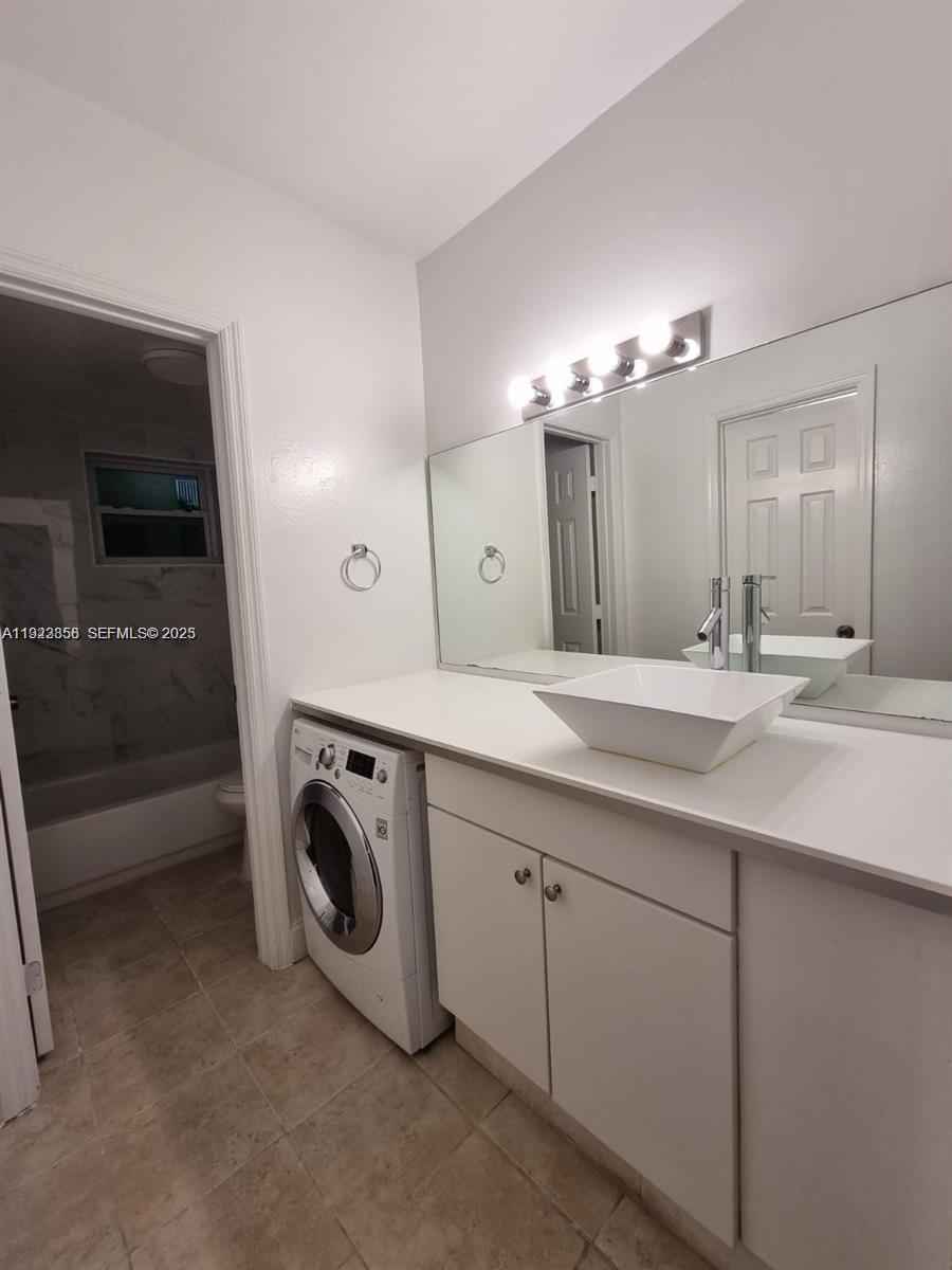 665 Northeast 83rd Terrace, Unit 112 Miami, FL 33138 - Photo 8 of 8 a bathroom with a sink a washer and dryer