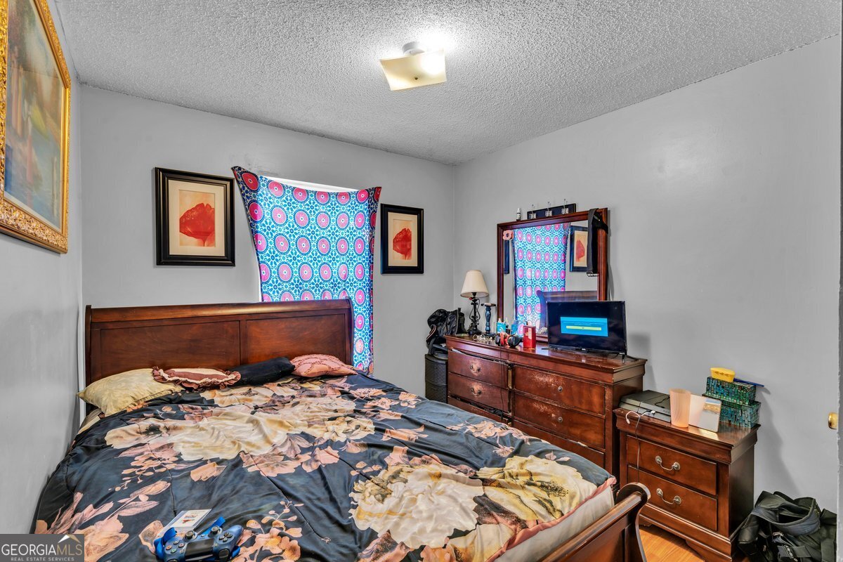 707 East 3rd Avenue Cordele, GA 31015 - Photo 13 of 21 a bedroom with a bed and dresser with mirror