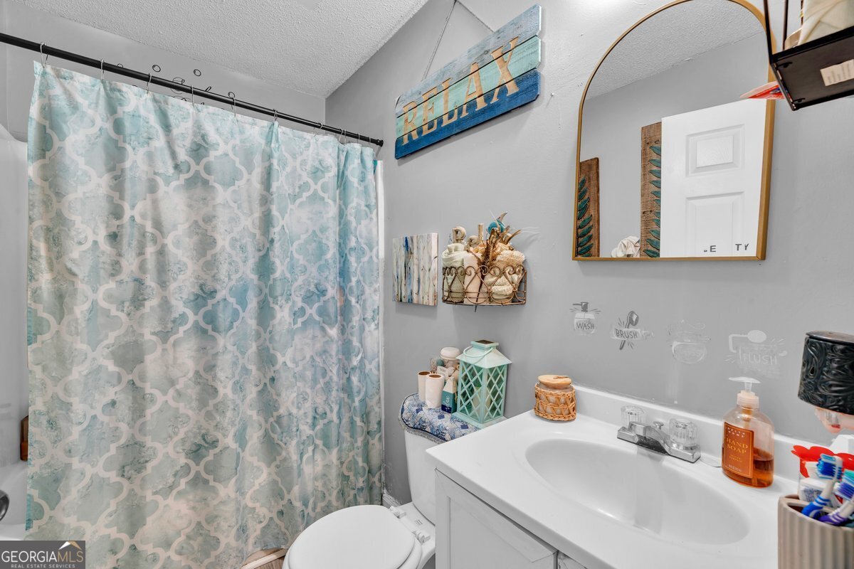 707 East 3rd Avenue Cordele, GA 31015 - Photo 15 of 21 a bathroom with a sink mirror and toilet