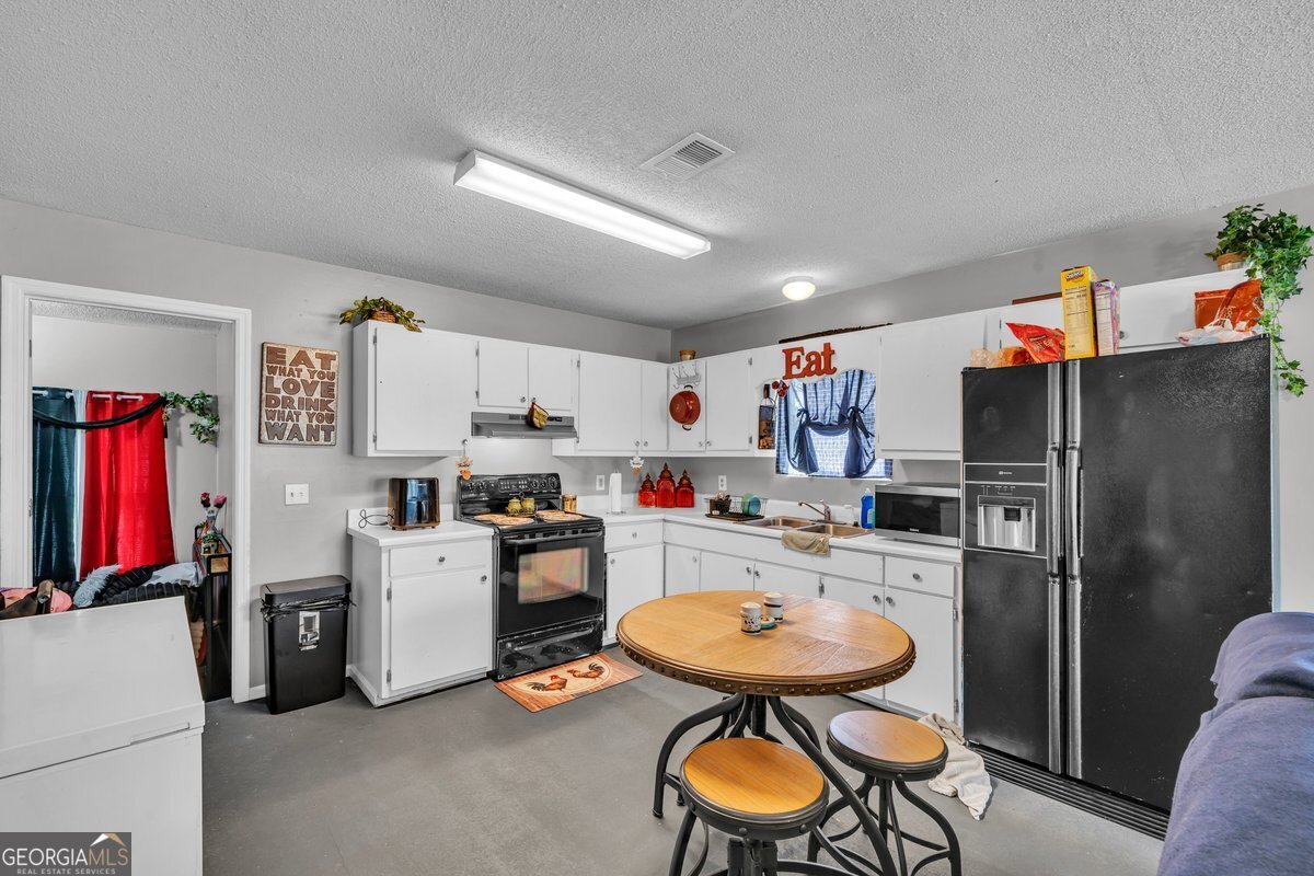 707 East 3rd Avenue Cordele, GA 31015 - Photo 6 of 21 a kitchen with stainless steel appliances a refrigerator and a stove