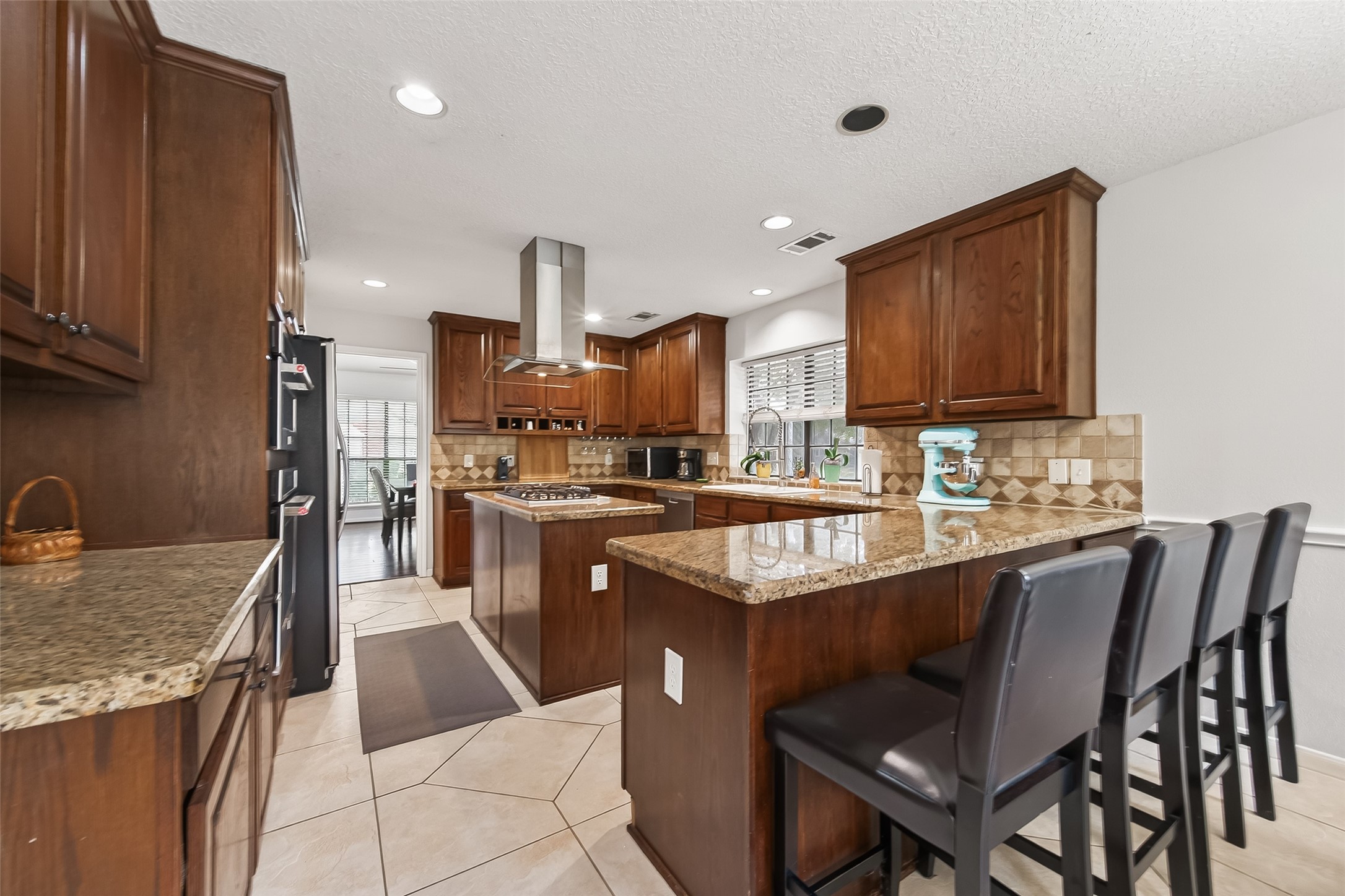18526 Fawn Run Lane Houston, TX 77084 - Photo 13 of 47 a kitchen with stainless steel appliances granite countertop a sink a stove a refrigerator cabinets and chairs