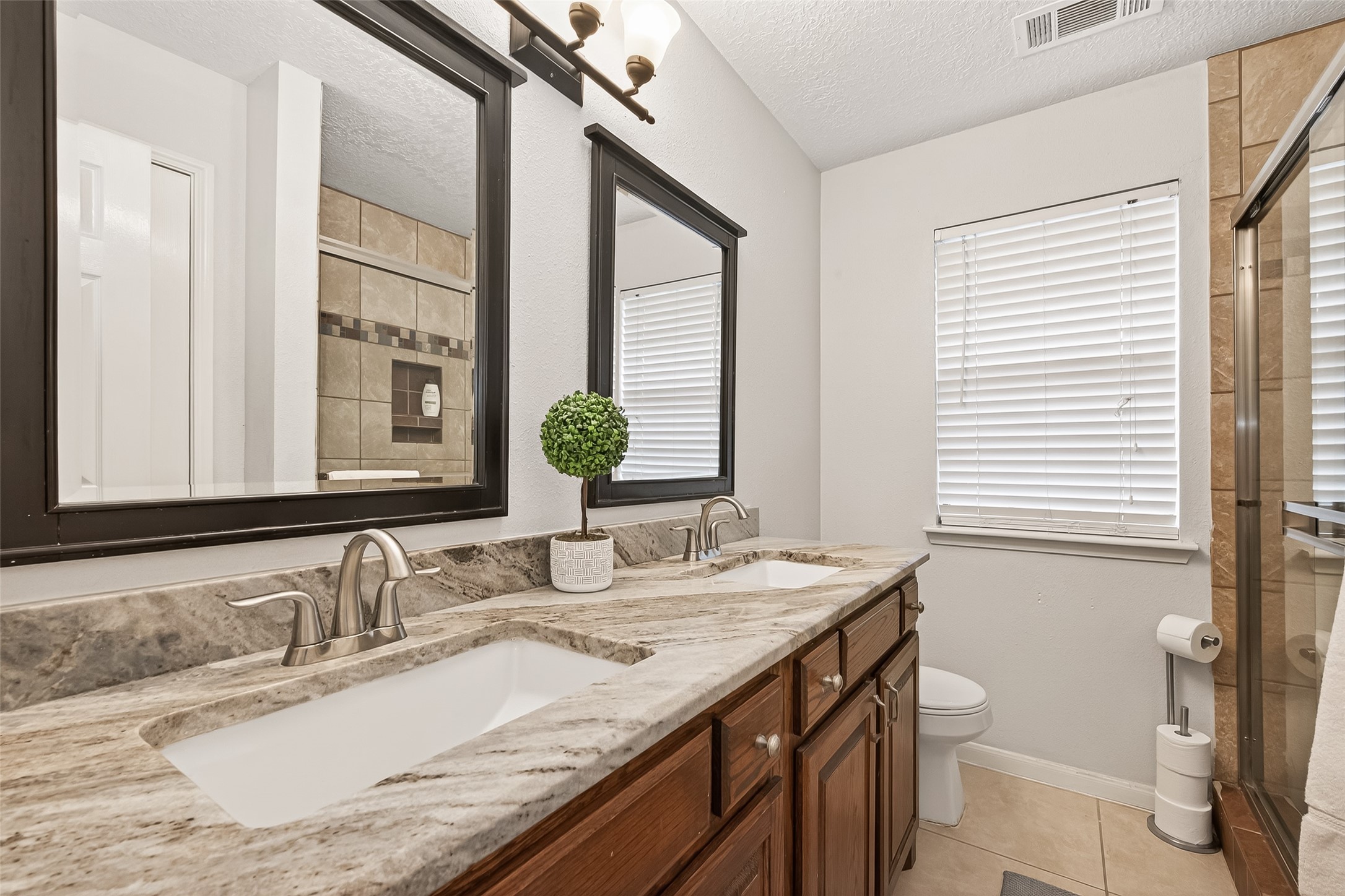18526 Fawn Run Lane Houston, TX 77084 - Photo 28 of 47 a bathroom with a granite countertop sink a toilet and a mirror