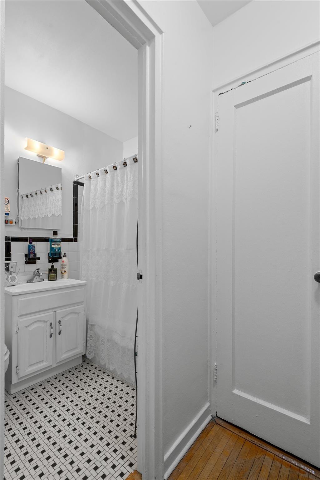 34-41 85th Street, Unit 4D Queens, NY 11372 - Photo 6 of 18 a bathroom with a sink a toilet a shower and a mirror