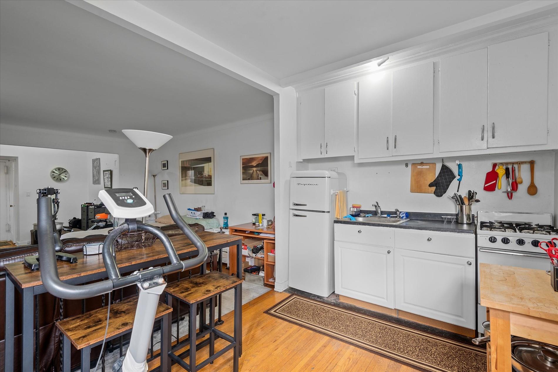 34-41 85th Street, Unit 4D Queens, NY 11372 - Photo 8 of 18 a kitchen with stainless steel appliances granite countertop a stove and white cabinets