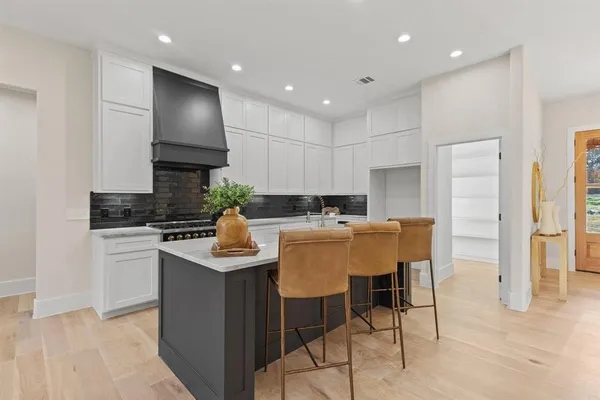 a kitchen with kitchen island granite countertop wooden cabinets and white appliances