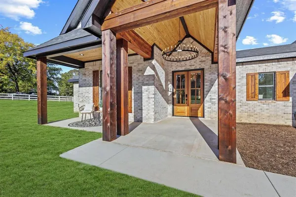 a view of a house with a small yard and floor to ceiling windows