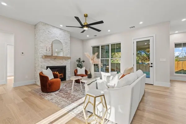 a living room with furniture kitchen view and a large window