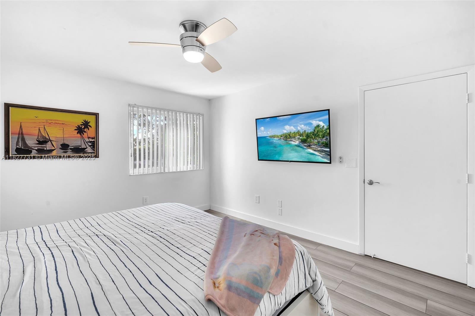 9525 Weldon Circle, Unit H305 Tamarac, FL 33321 - Photo 15 of 26 a bedroom with bed and a painting on the wall