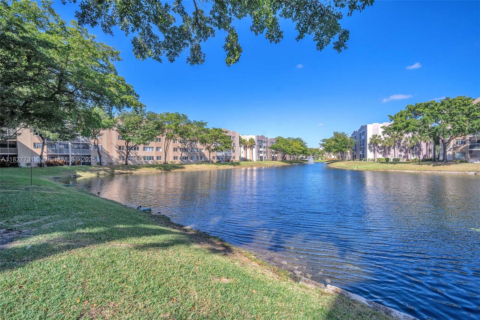 9525 Weldon Circle, Unit H305 Tamarac, FL 33321 - Photo 21 of 26 a view of a lake with houses in the background