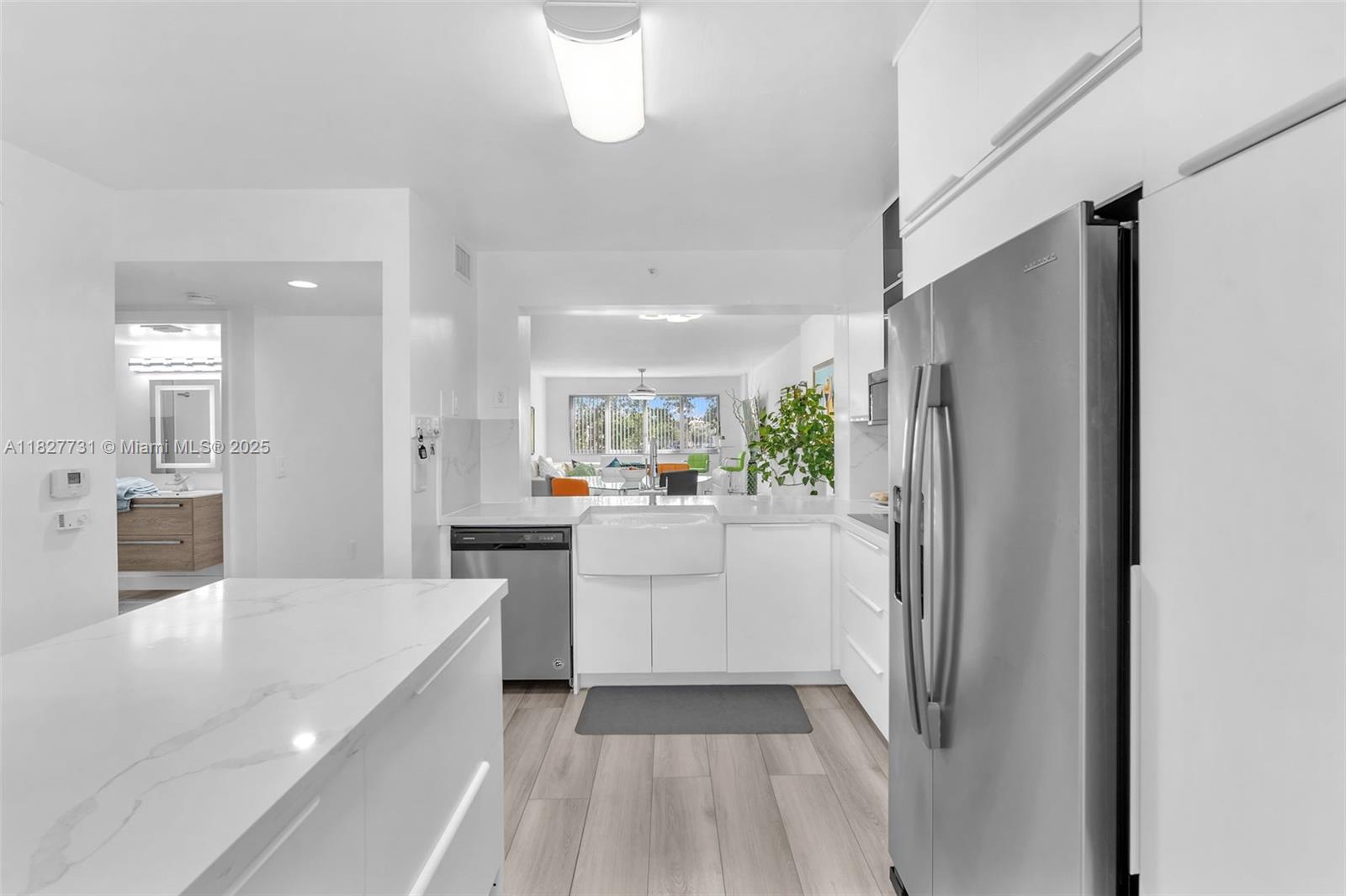 9525 Weldon Circle, Unit H305 Tamarac, FL 33321 - Photo 6 of 26 a kitchen with white cabinets and refrigerator