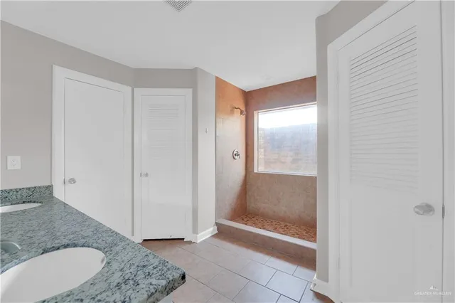 a bathroom with a granite countertop sink and a mirror