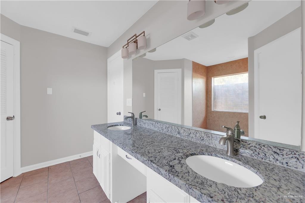 7008 North 30th Street McAllen, TX 78504 - Photo 13 of 18 a bathroom with a granite countertop sink and a mirror