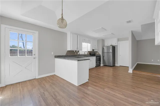 a kitchen with stainless steel appliances granite countertop a refrigerator and a stove top oven