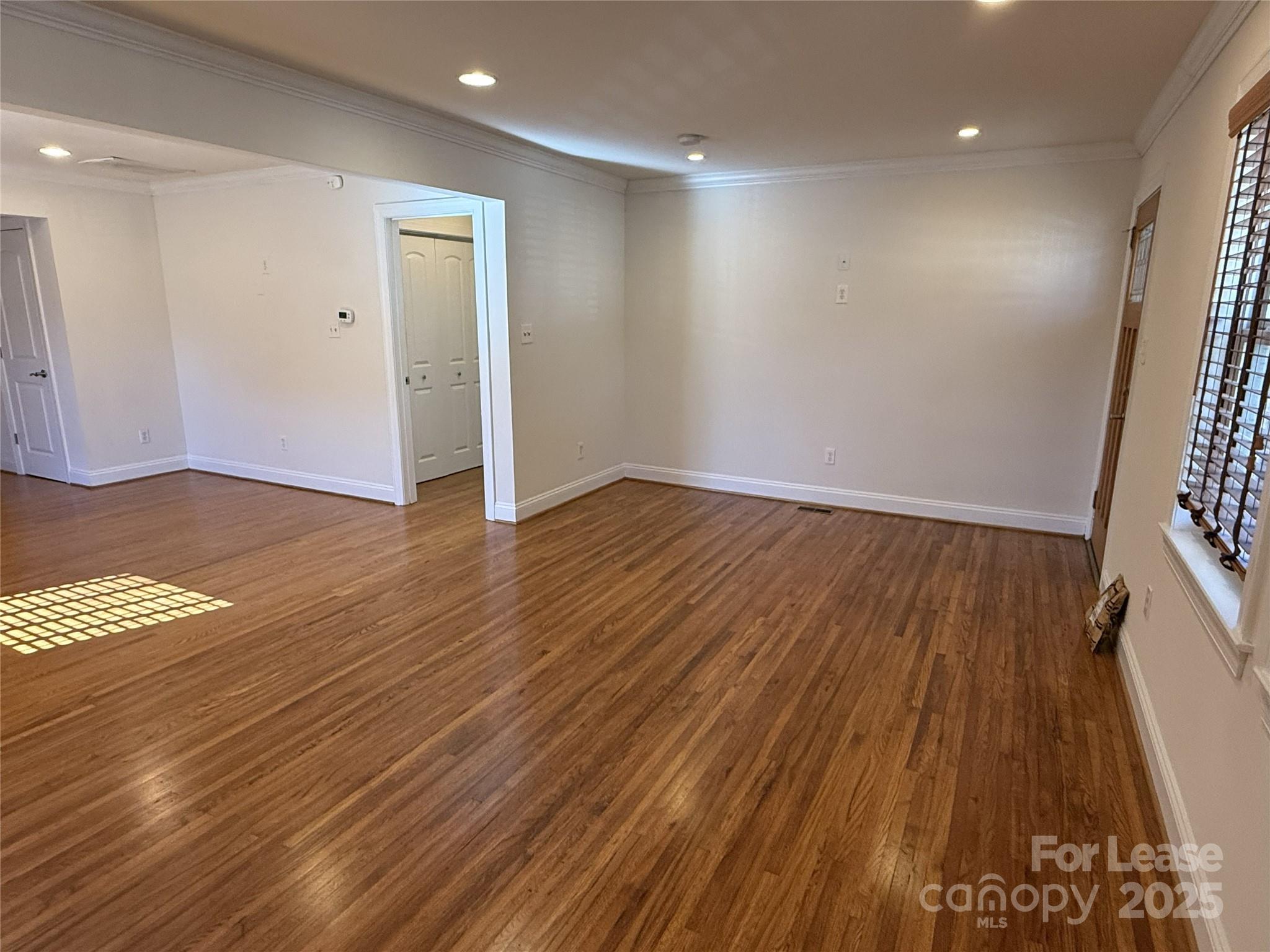 350 Melbourne Court Charlotte, NC 28209 - Photo 3 of 22 an empty room with wooden floor and windows