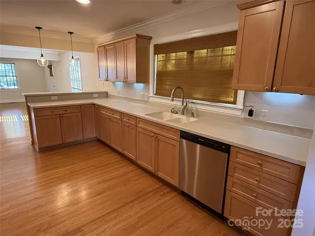 a kitchen with stainless steel appliances granite countertop a sink and wooden cabinets