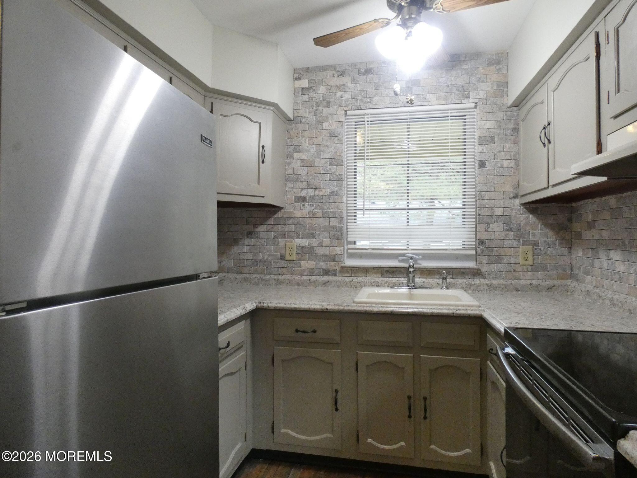 33D Medford Road, Unit A Manchester Township, NJ 08759 - Photo 13 of 24 a kitchen with stainless steel appliances granite countertop a sink a stove and a refrigerator