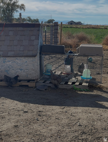 289 West Center Street Hinckley, UT 84635 - Photo 8 of 13 Agricultural outbuilding featuring a shingle roof, wire mesh enclosure, and natural terrain