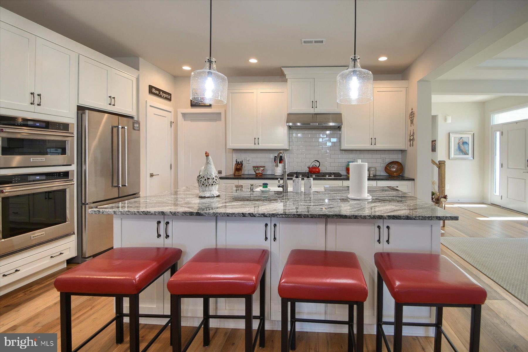 6963 Maple Drive Bath, PA 18014 - Photo 10 of 46 a kitchen with granite countertop a table chairs microwave and cabinets