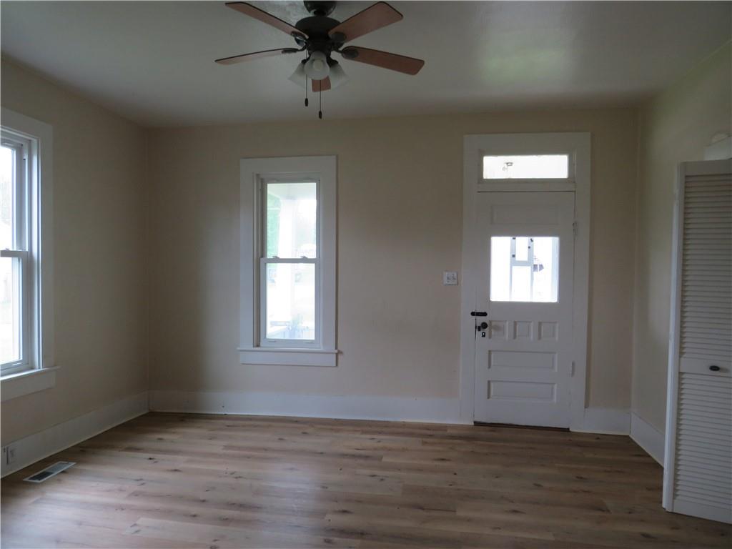 318 Old Ash Road Mercer, PA 16137 - Photo 4 of 15 an empty room with wooden floor fan and windows