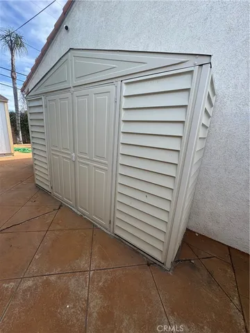 a patio with a table and chairs and potted plants