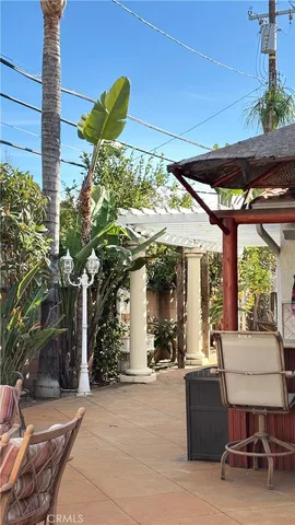 a view of a patio with table and chairs under an umbrella