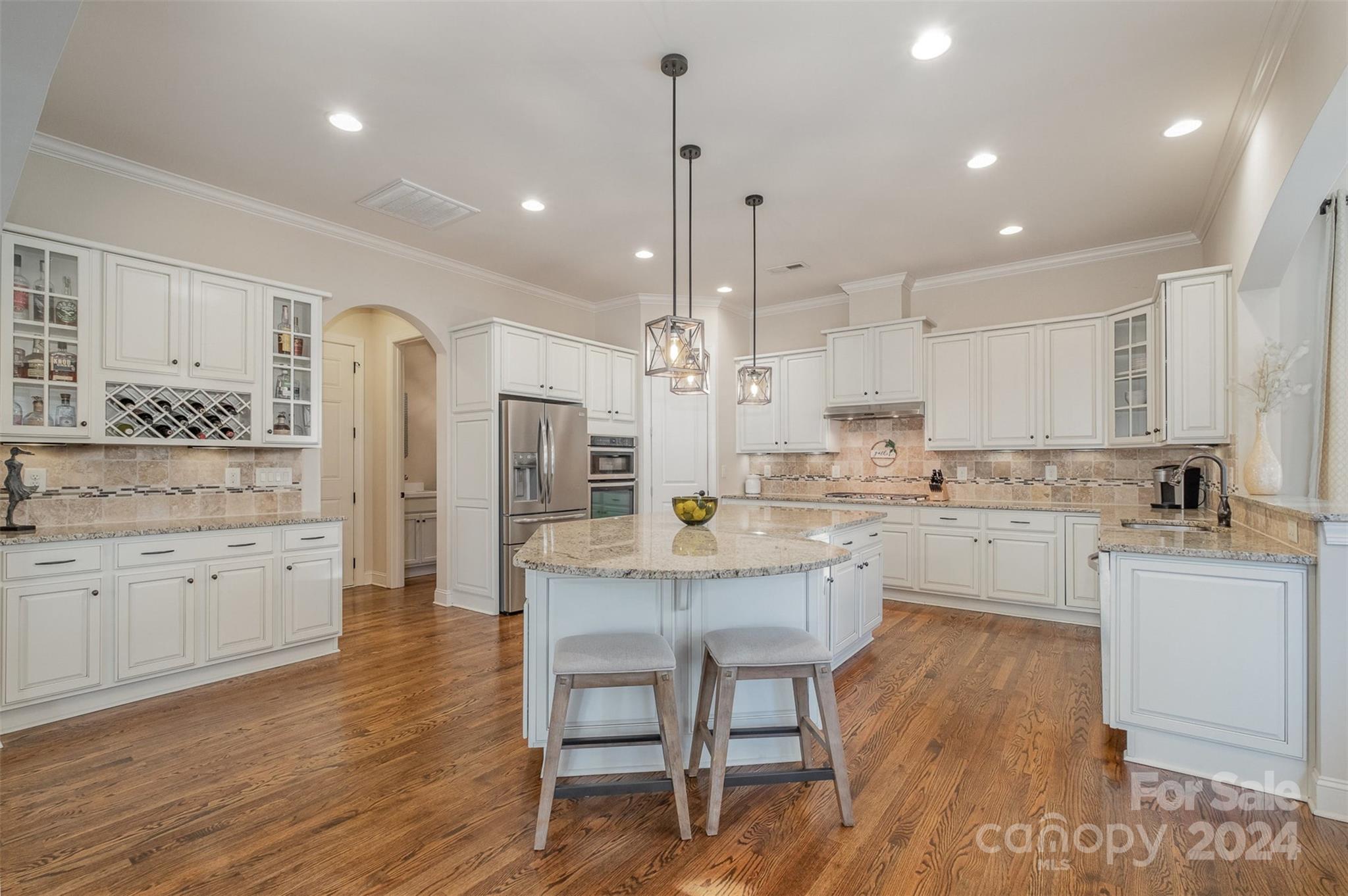 6926 Potter Road Weddington, NC 28104 - Photo 13 of 46 a kitchen with stainless steel appliances kitchen island granite countertop a stove a sink a refrigerator and white cabinets with wooden floor