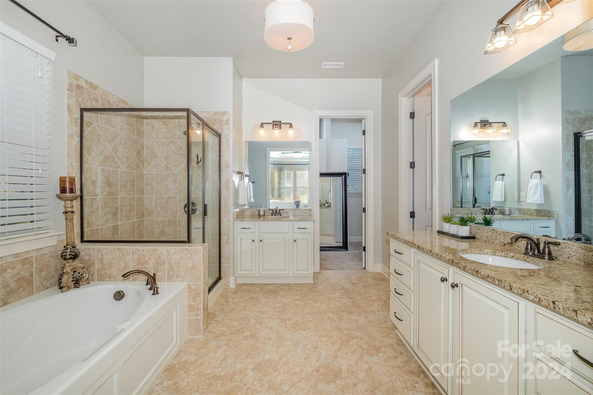 6926 Potter Road Weddington, NC 28104 - Photo 23 of 46 a bathroom with a granite countertop tub sink double vanity granite tub shower and mirror