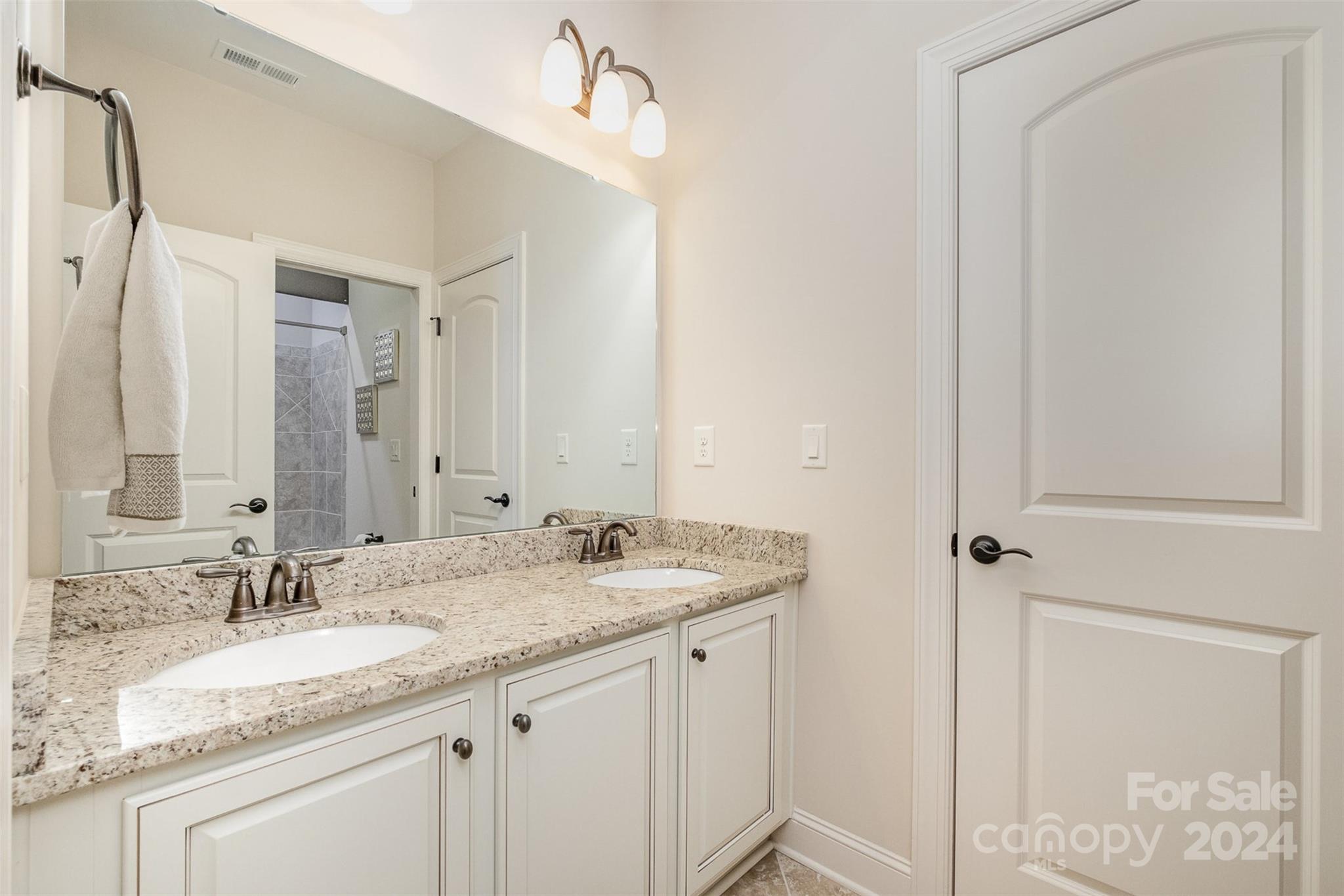 6926 Potter Road Weddington, NC 28104 - Photo 27 of 46 a bathroom with a granite countertop sink and a mirror