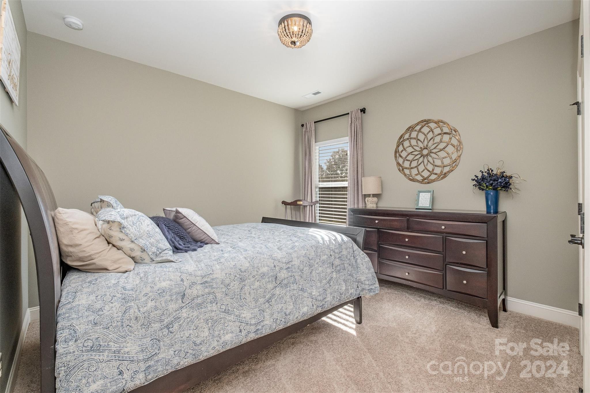 6926 Potter Road Weddington, NC 28104 - Photo 32 of 46 a bedroom with a bed and a table with a chandelier