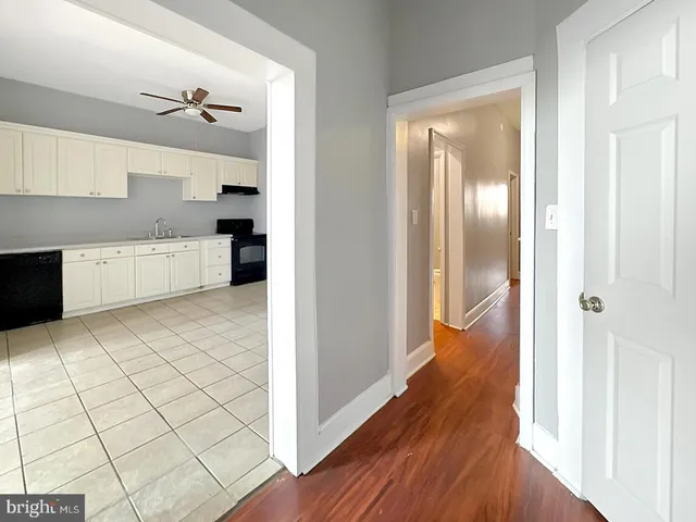 a view of a kitchen with wooden floor electronic appliances and furniture