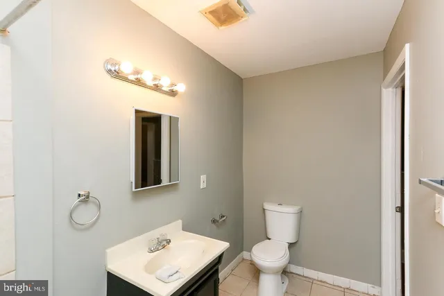 a bathroom with a toilet a sink and mirror